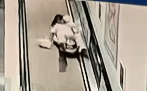 足球信用网开户 _女子怀抱五个多月的婴儿在扶梯上被身后玩具车撞倒足球信用网开户 ，怀中婴儿也被摔倒在地！已报警